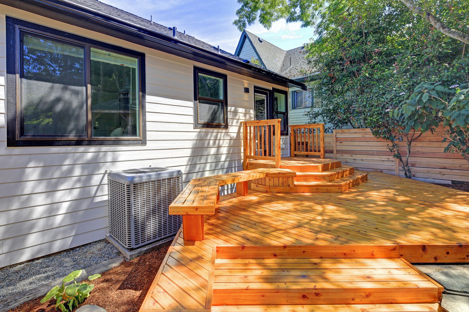 A house with a wooden deck and stairs in front of it.